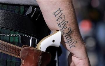 (AP Photo/Eric Gay, File). FILE - In this Jan. 26, 2015 file photo, Scott Smith, a supporter of open carry gun laws, wears a pistol as he prepares for a rally in support of open carry gun laws at the Capitol, in Austin, Texas.